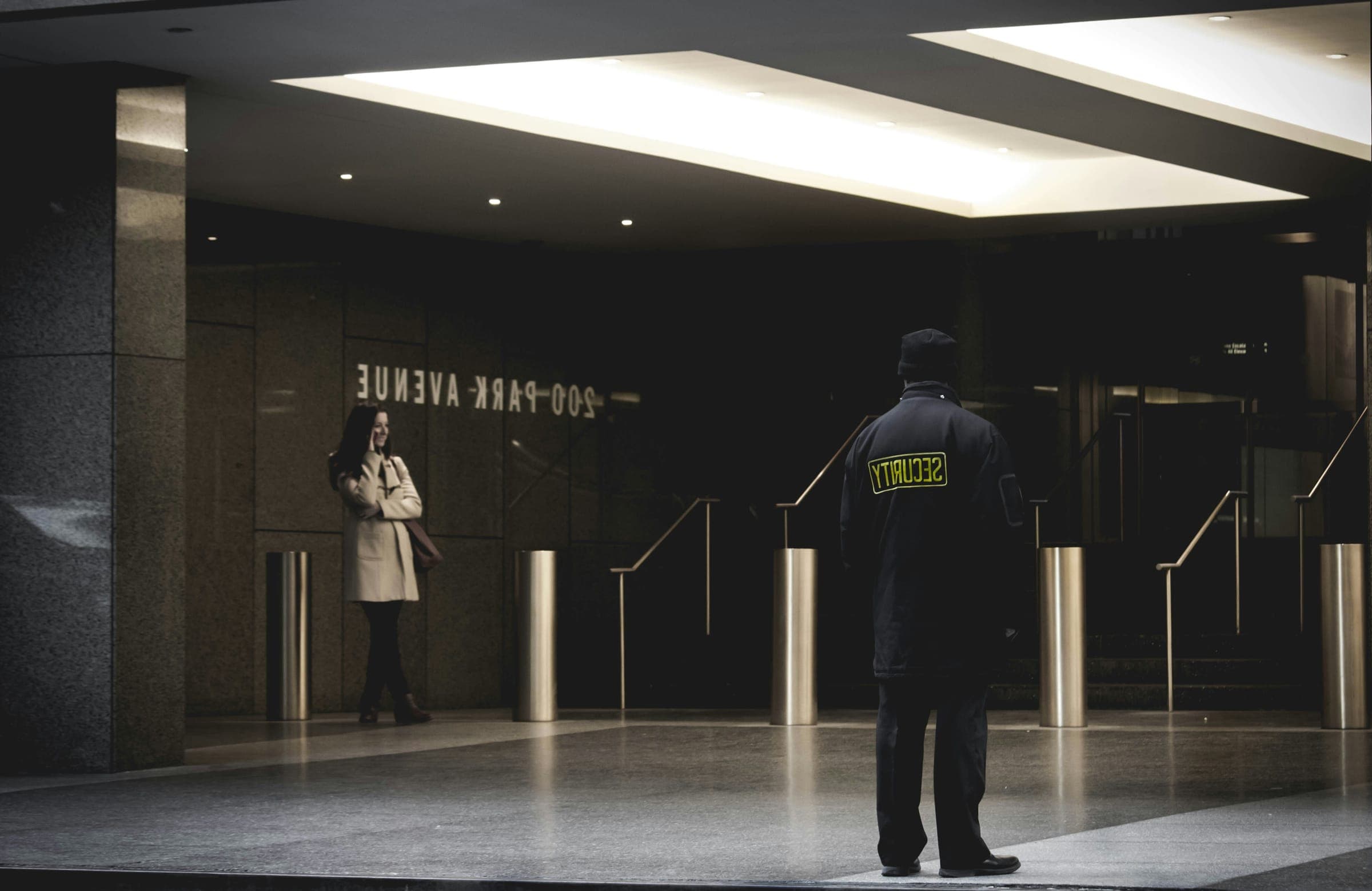 Security officer standing watch in a building lobby at night
